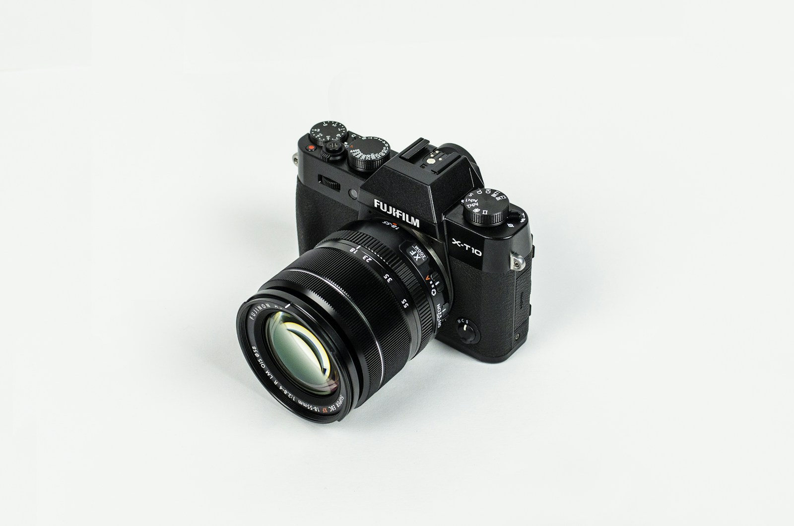 Fujifilm X-T10 camera with attached zoom lens on a white surface