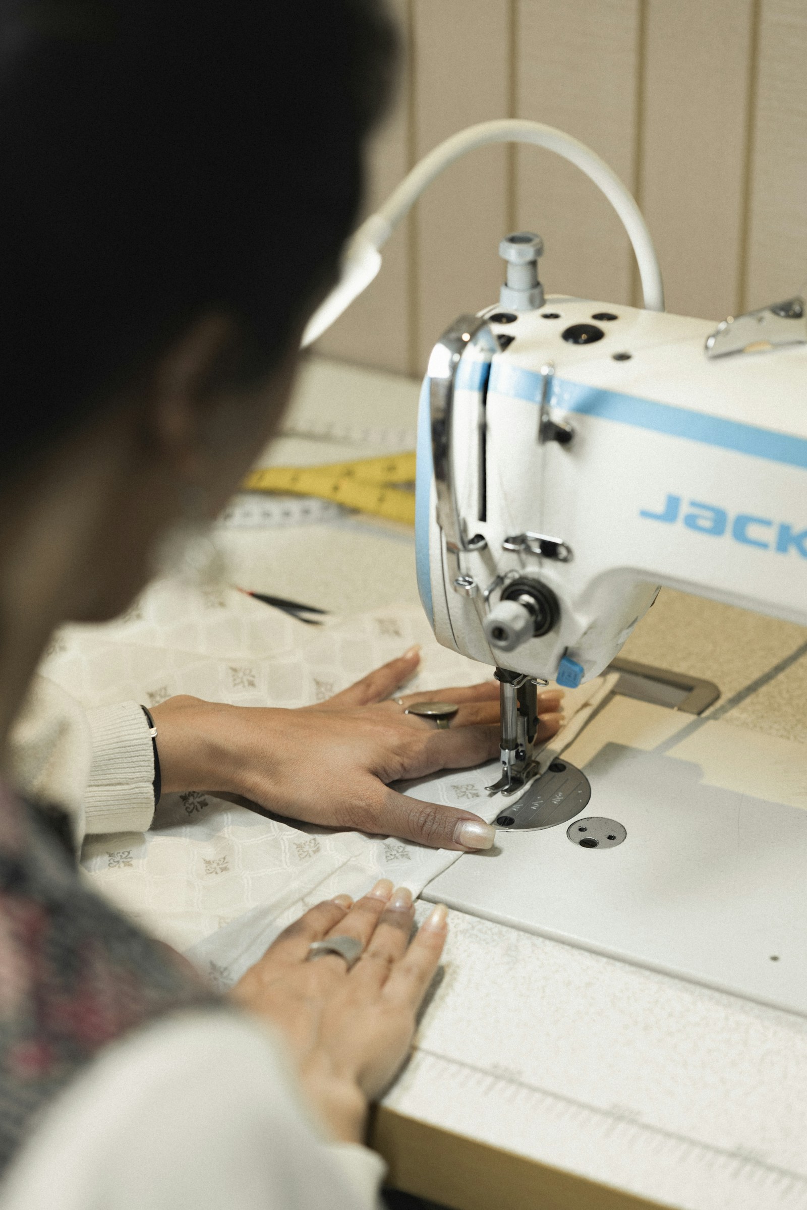 Sewing class participant working at a machine with fabric